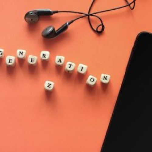 black smartphone and earphones. Dice with letters Generation Z.